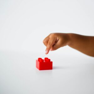 child pointing to red interlocking brick toy