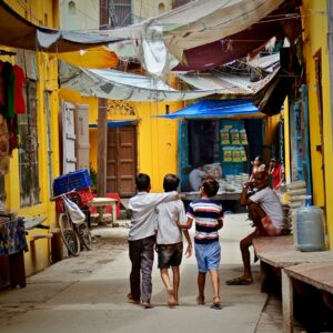 three boys walking between buildings at daytime